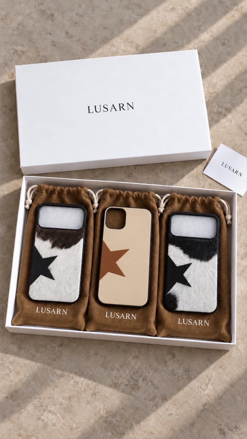 Tres fundas LUSARN en sus cubrepolvos dentro de una caja blanca de la marca
